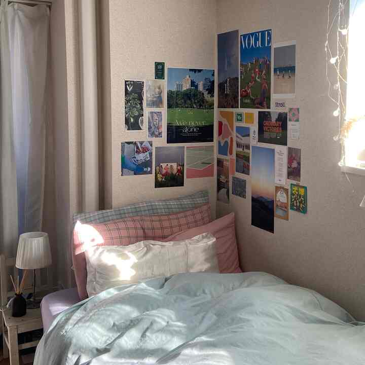 ナチュラルカラーの寝室、チェック柄の枕と多彩なウォールデコが調和する温かな雰囲気のインテリア