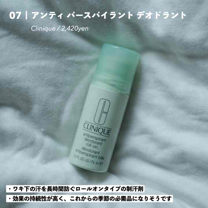 白と淡い緑色のトーンのパーソナルケア用品、白い布の上に置かれたクリニークのデオドラントが印象的な空間