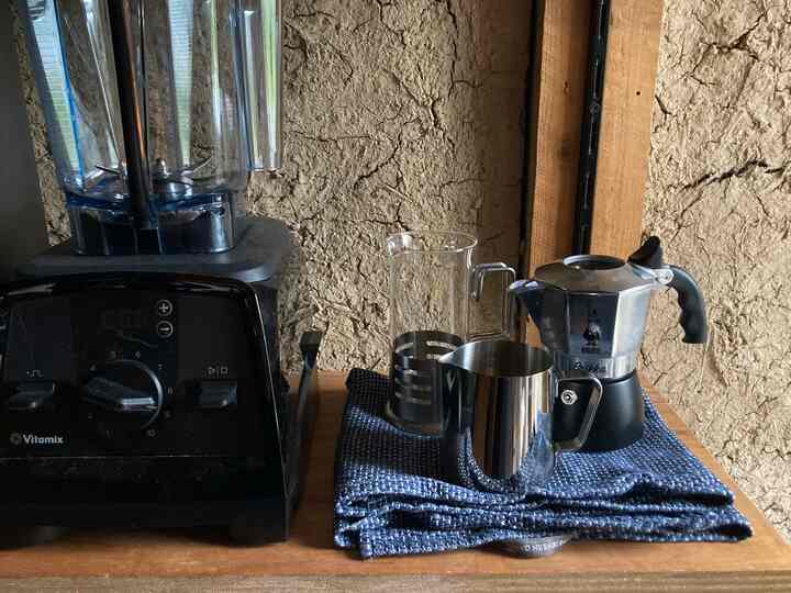 茶色の木目調と黒が調和した小さなキッチンパントリーコーナー、高性能ブレンダーとブリッカのコーヒーメーカーが置かれた温かみのある空間