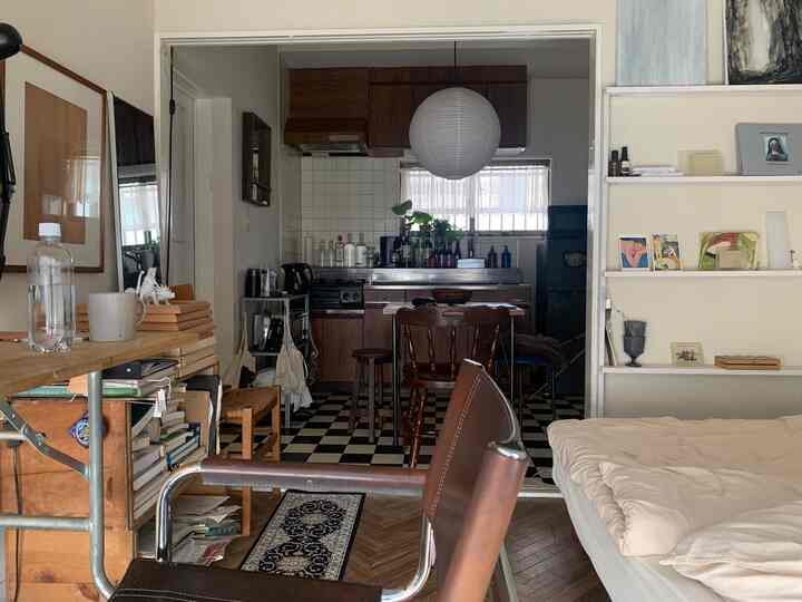 White and brown toned studio apartment featuring dining room and kitchen in natural modern style