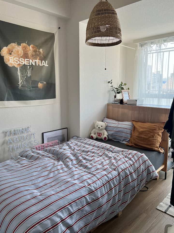 Natural tone small 4.5 tatami bedroom featuring bed, pendant light, curtains, and poster in a simple cozy setting