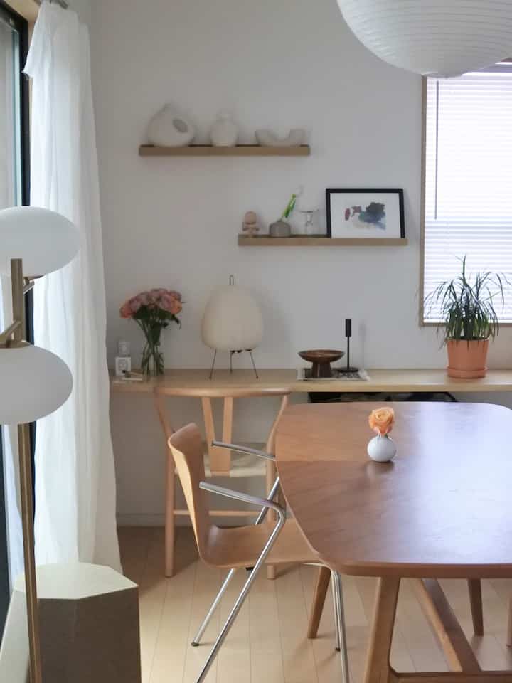 Natural wood-tone dining room featuring simple shelving and lighting with a clean, uncluttered atmosphere
