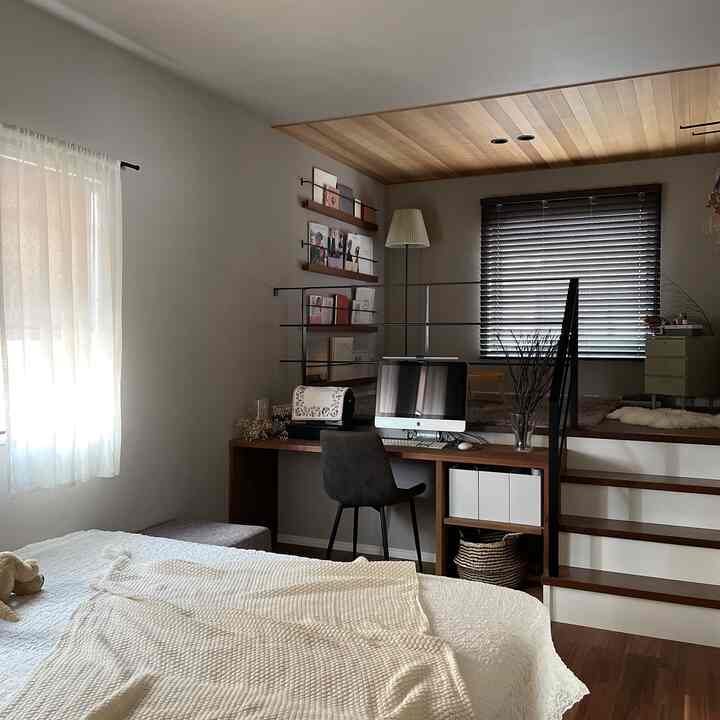 ブラウンの木目調とホワイトが調和したナチュラルモダンな寝室、ベッドとデスク付きのロフト空間が配置された雰囲気のあるインテリア