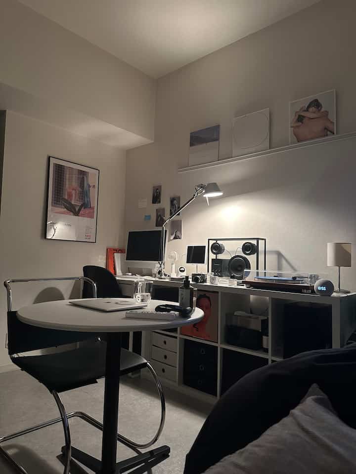 White-toned compact home office space featuring a black office chair and desk in a neat, minimalistic interior