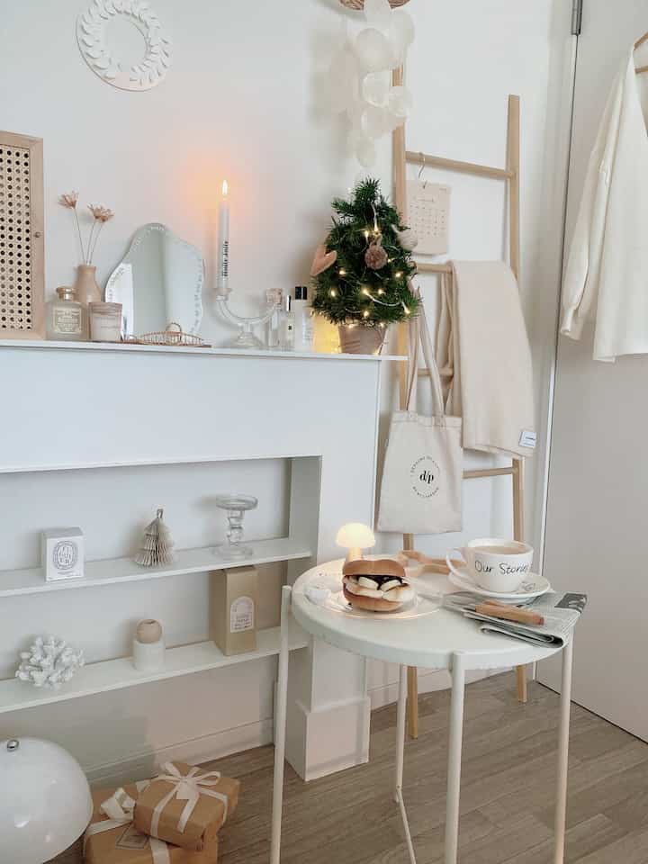 Natural-style small room in white and wood tones, featuring a side table with a mini Christmas tree and cozy decor