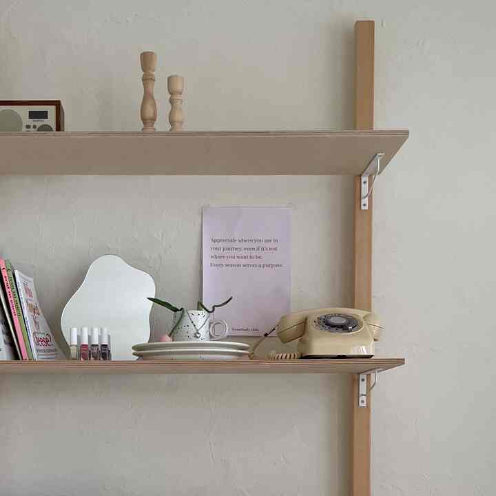 白とナチュラルウッドの壁棚が配されたミニマルでヴィンテージ感のあるインテリア