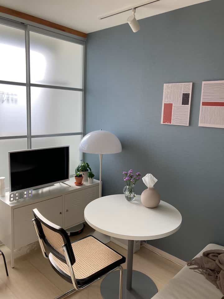 White and blue toned living room featuring a TV stand and round table with a cozy atmosphere