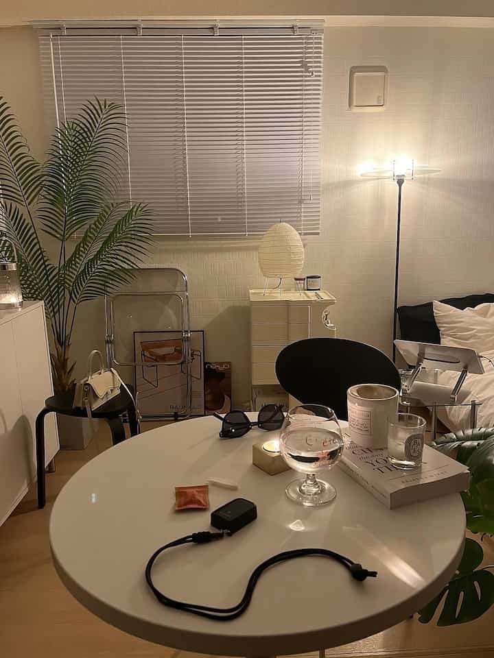 白と黒のトーンが特徴のモダンなリビング、丸テーブルと照明、シンプルな家具と植物が配置された印象的な空間