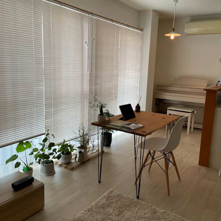 Beige and white toned living room featuring a wooden table and plants with a natural, calm atmosphere