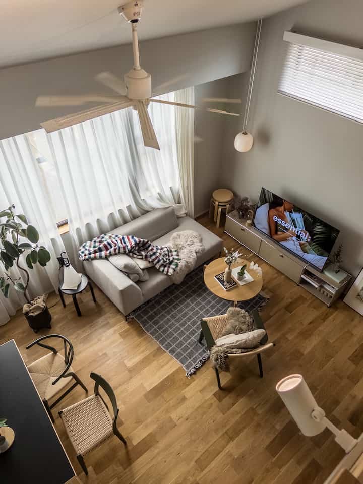A Nordic living room with white and wood tones, featuring a sofa and coffee table creating a cozy atmosphere