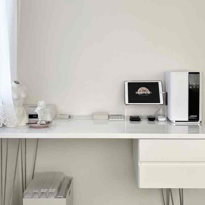 White-toned compact home office space featuring a large desk and neat storage, creating a simple and spacious atmosphere