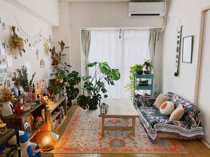 ナチュラルカラーと木目調のリビング、鮮やかな植物と柄のソファが印象的な雰囲気のあるインテリア