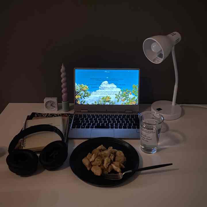 ホワイトとブラックの調和のとれたシンプルなホームオフィス、デスクにノートパソコンと食事が配置された雰囲気のある空間