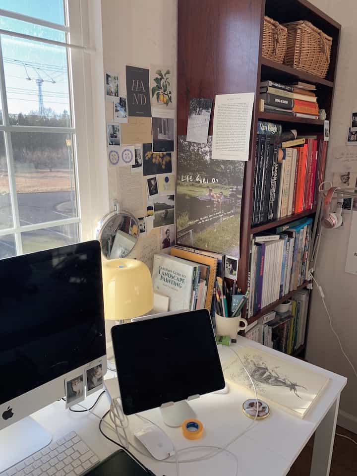 白と茶色のトーンの書斎、書棚と机にモニターとタブレットが配置された雰囲気のある作業スペース