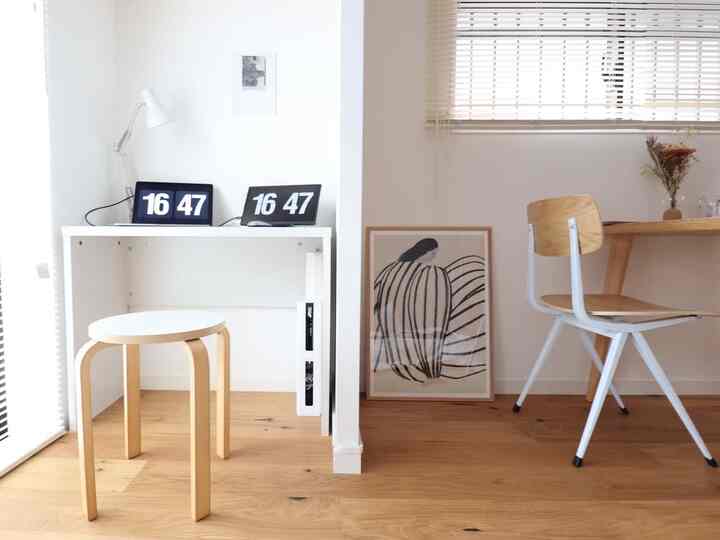 白い壁とナチュラルな木目調家具が配置されたワンルームのホームオフィス、清潔で落ち着いた雰囲気のあるインテリア