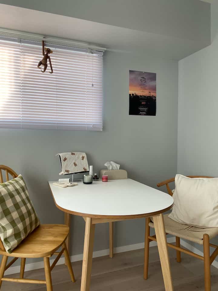 White and natural wood tone dining room featuring small table and chairs creating a cozy space