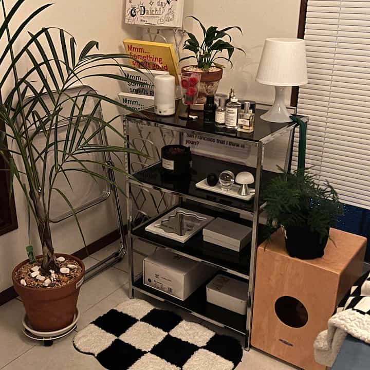 温かみのあるベージュ調のリビングコーナー、透明な椅子と植物が配置されたミッドセンチュリーモダンの雰囲気あるインテリア