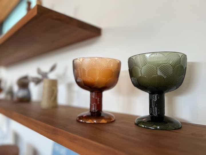 ナチュラルカラーの棚に配置された二つのガラスボウルが印象的な温かみのある空間