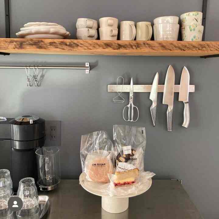 グレー調のキッチン空間、木製の棚とステンレス調理器具が整然と配置されたモダンな雰囲気のインテリア