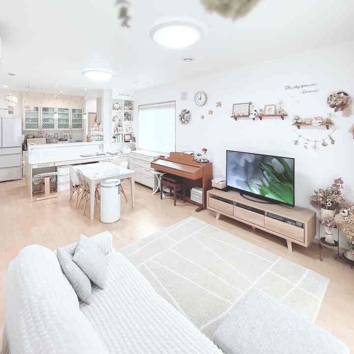 白と木目調が調和した1LDKのリビング・ダイニングルーム、電子ピアノとテレビ台が配置されたナチュラルモダンな空間