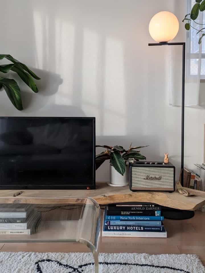 シンプルでナチュラルカラーのリビング、木製のテレビ台にマシュースピーカーとフロアランプが配置された空間