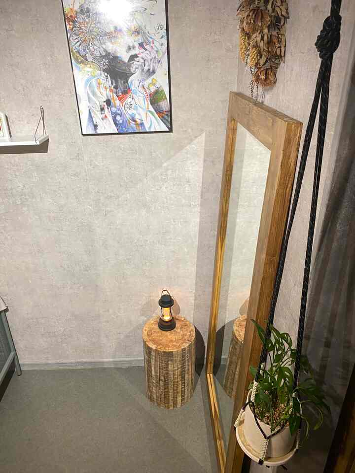 ベージュとグレーの壁紙と木目調家具が調和するナチュラルモダンなリビング、プランターとアートポスターが雰囲気を演出するインテリア