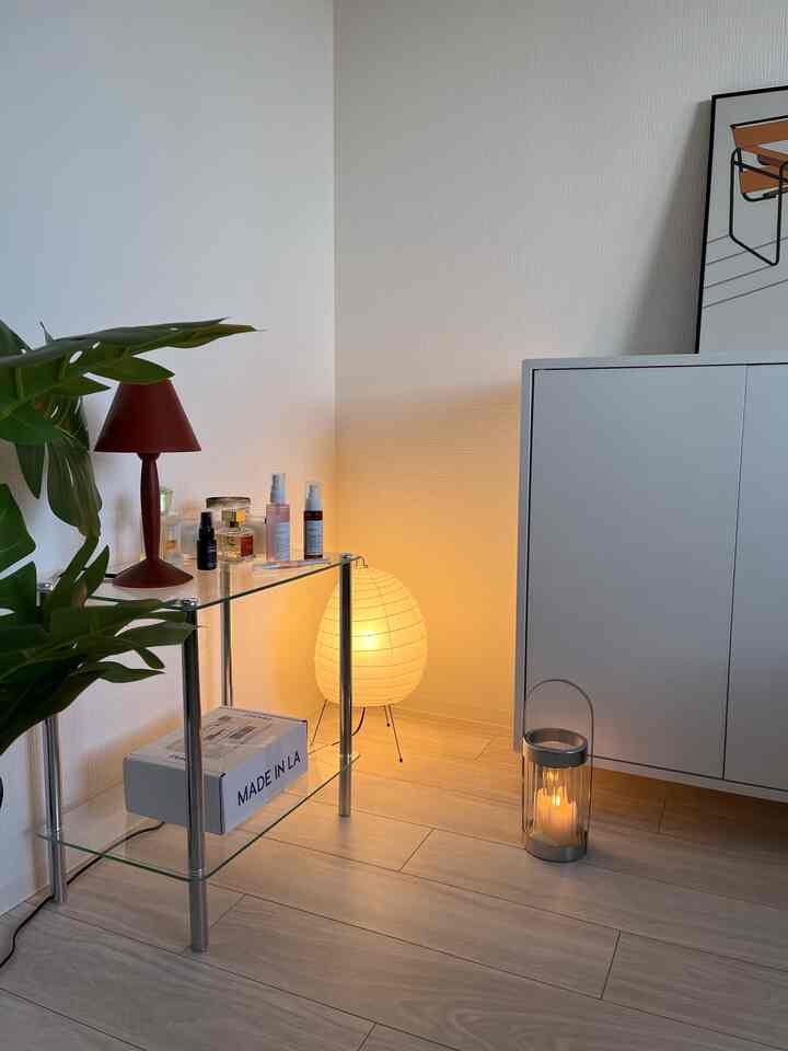 Living room in white and brown tones featuring glass shelving and cabinet with minimalist style