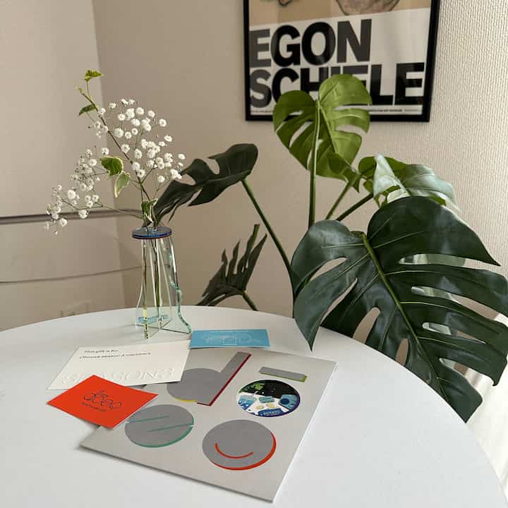 透明な花瓶と緑の植物が配置されたシンプルなダイニング、清潔で自然な雰囲気のあるインテリア