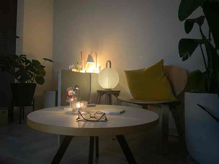 Cozy 4.5 tatami room featuring an armchair with light yellow cushion, round table, and warm mood lighting