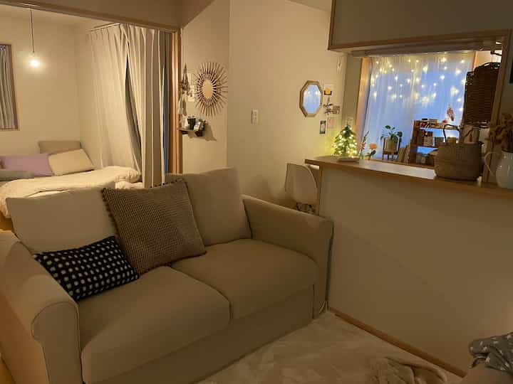 ベージュとナチュラルな色調のリビング、ベージュのソファとクッション、温かみのある照明が配置された雰囲気の良いインテリア