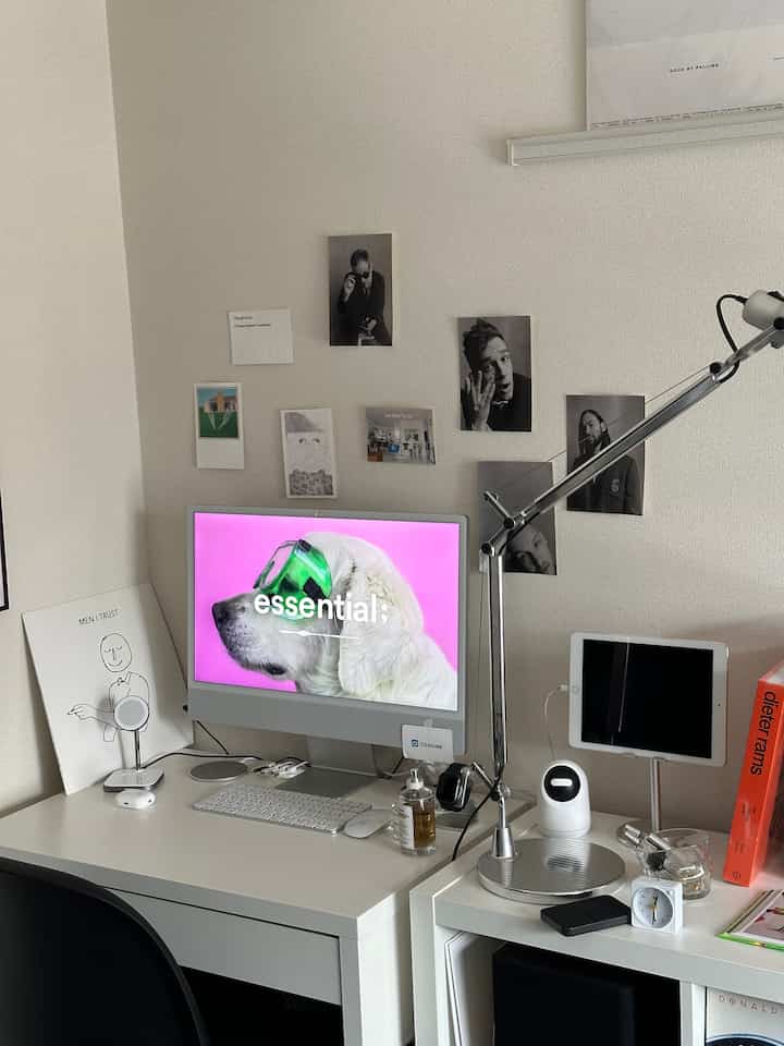 白を基調としたホームオフィス、デスクとiMac、整ったレイアウトと雰囲気のあるアートプリントが配置された空間