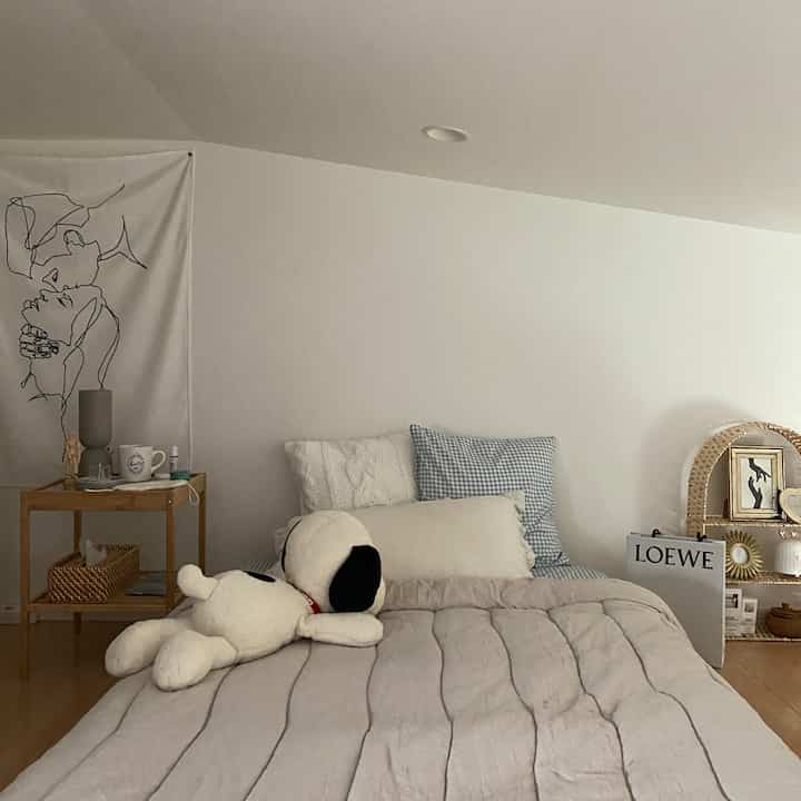 Natural toned bedroom featuring beige blanket and cushions, creating a cozy atmosphere