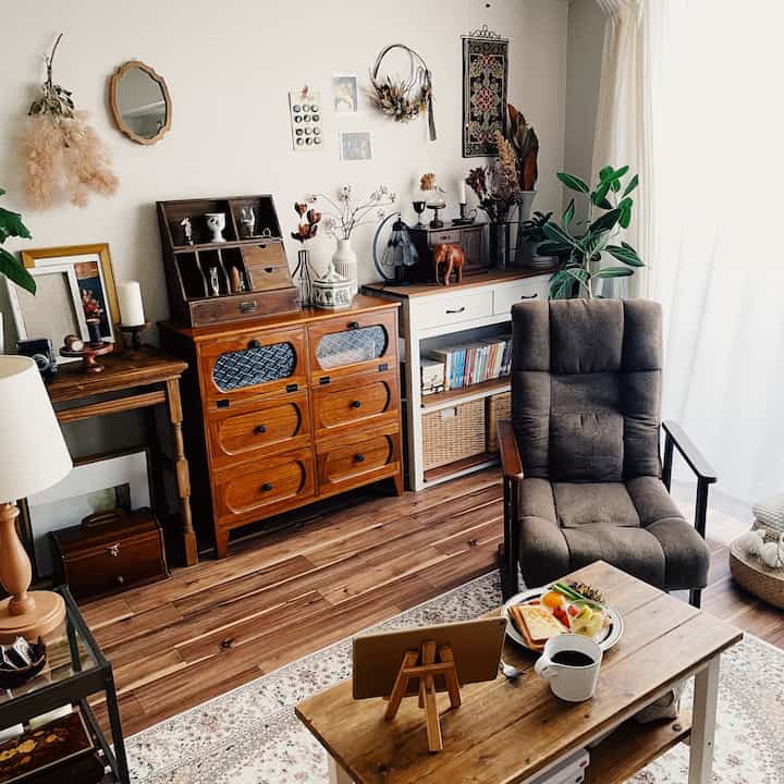 ナチュラルなブラウン調のリビング、木製家具とファブリックのアームチェアが配置された雰囲気のある空間