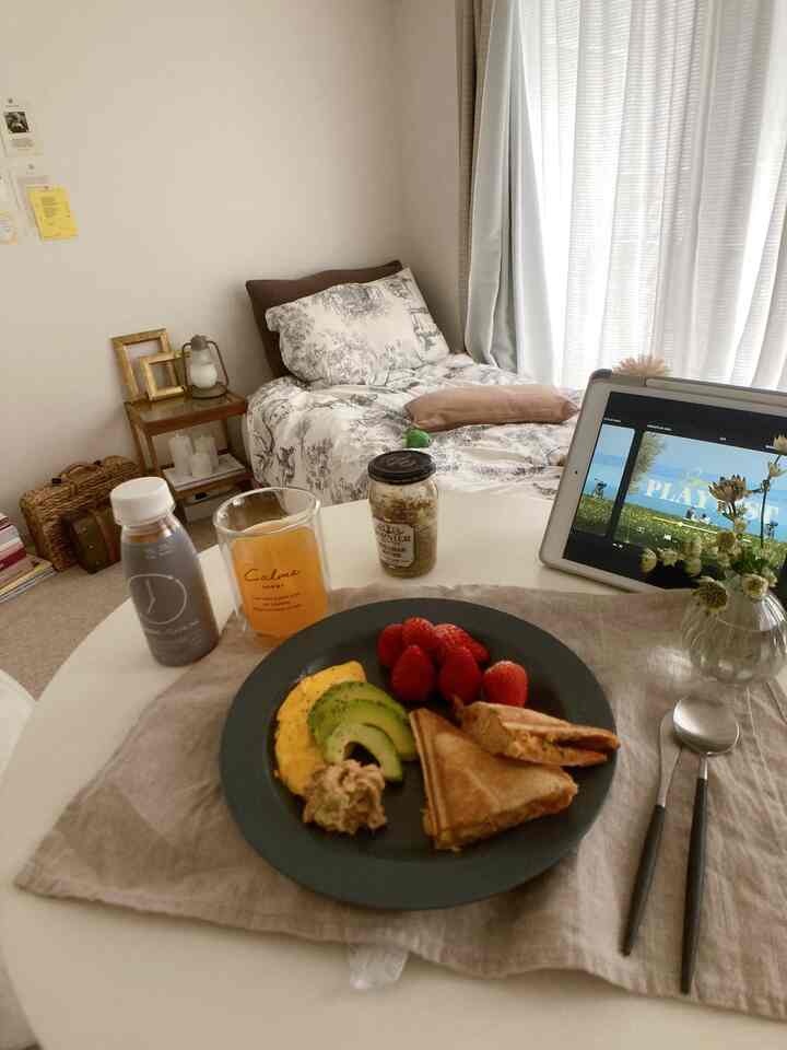 Beige and white toned bedroom featuring a bed, nightstand, and a home cafe style hot sandwich brunch with cozy atmosphere