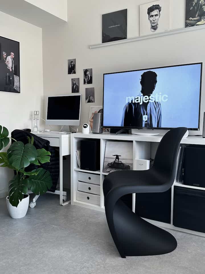 Modern home office space with white background and black Panton Chair, featuring a clean and simple atmosphere