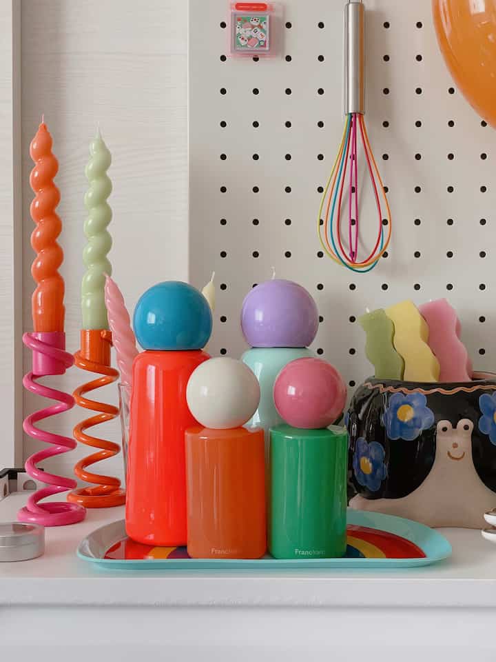 Colorful retro-style space featuring vibrant candles and objet d'art with a bright, playful atmosphere
