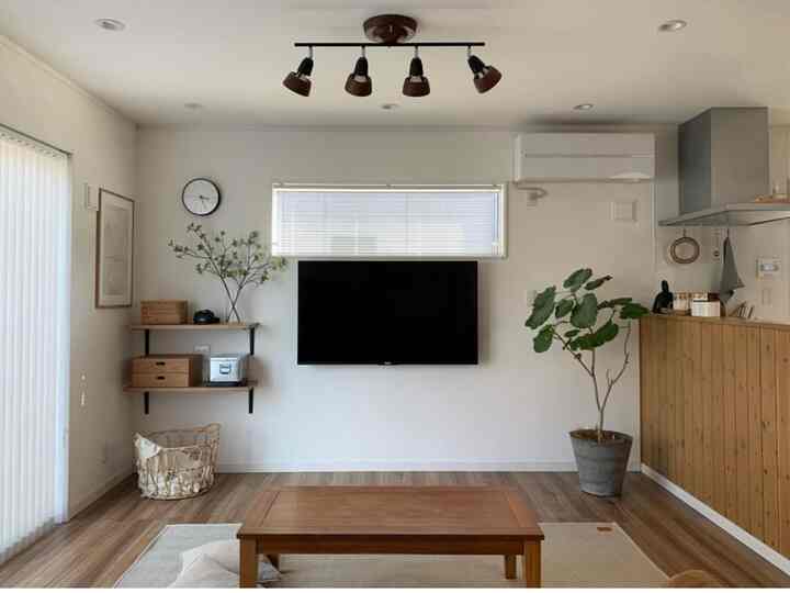 Simple natural modern living room with white walls and natural brown wooden furniture creating a calm atmosphere
