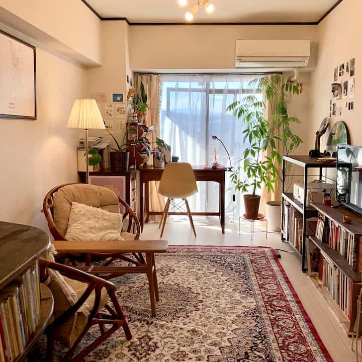 Natural toned 4.5畳 living room featuring wooden furniture, a Persian rug, and plants creating a cozy home office atmosphere