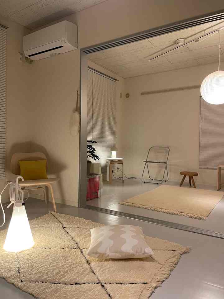 A small natural-toned room featuring soft rugs and simple furniture with a cozy atmosphere