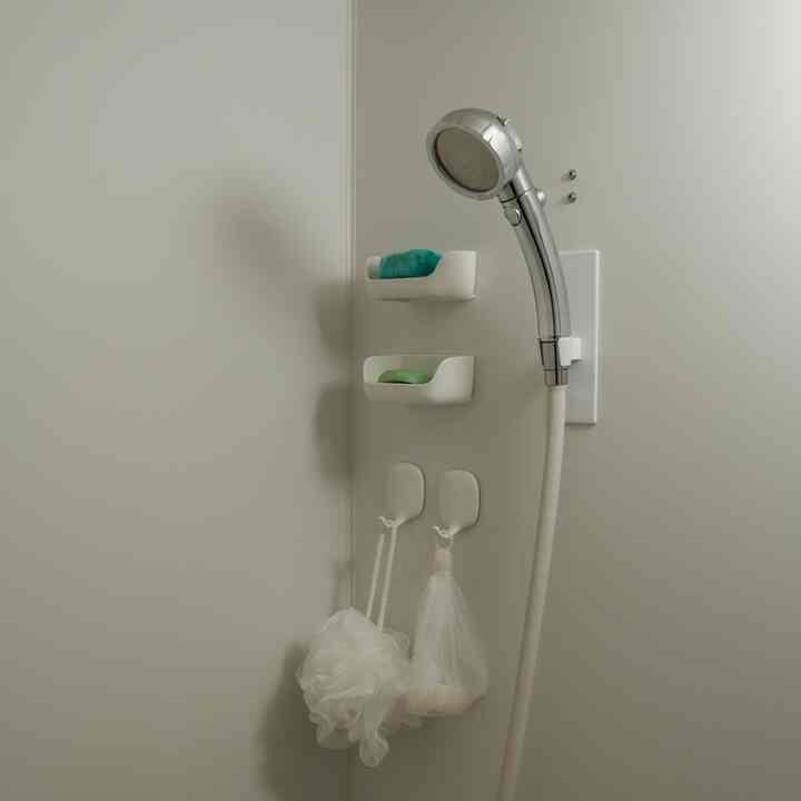 White-toned bathroom featuring tidy magnet shower hooks and minimalist design