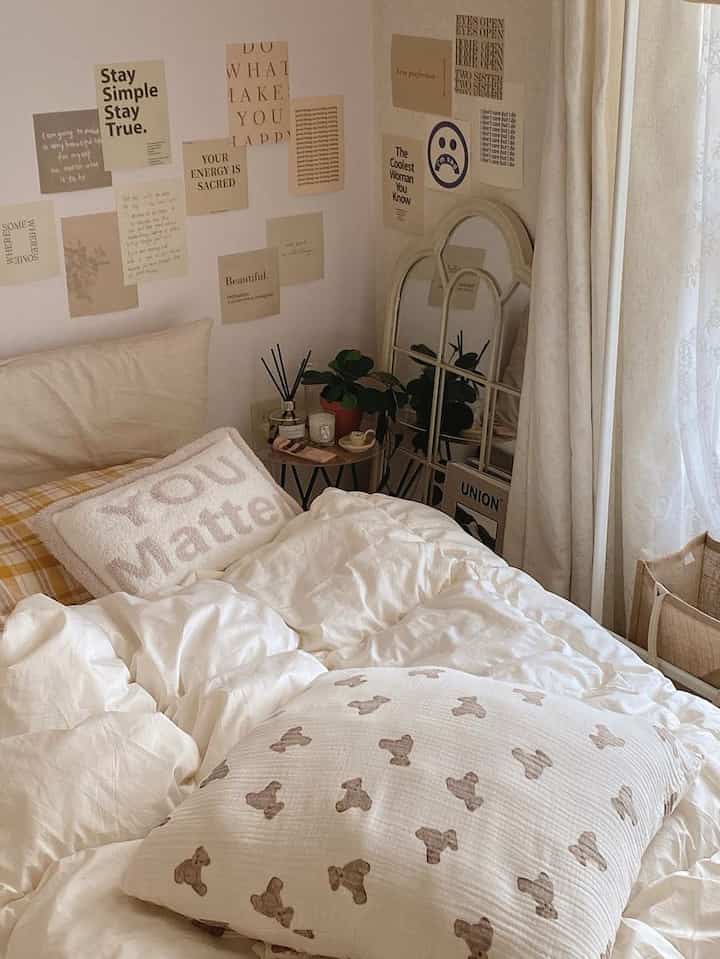 白とベージュの色調の寝室、寝具と枕が配置された落ち着いた印象的な空間