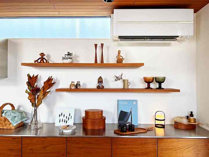 Natural kitchen space with white walls and wood tone shelves, featuring simple decor creating a calm and natural atmosphere