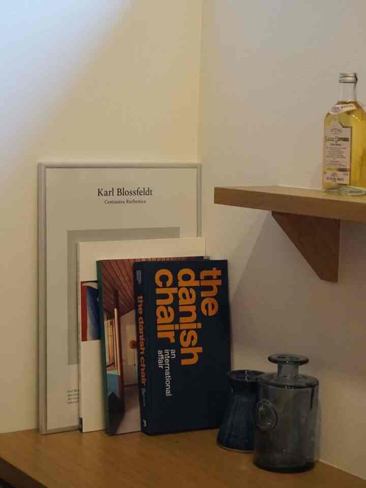 Natural wood tone and ivory entrance space featuring books, diffuser, and vases with a cozy atmosphere