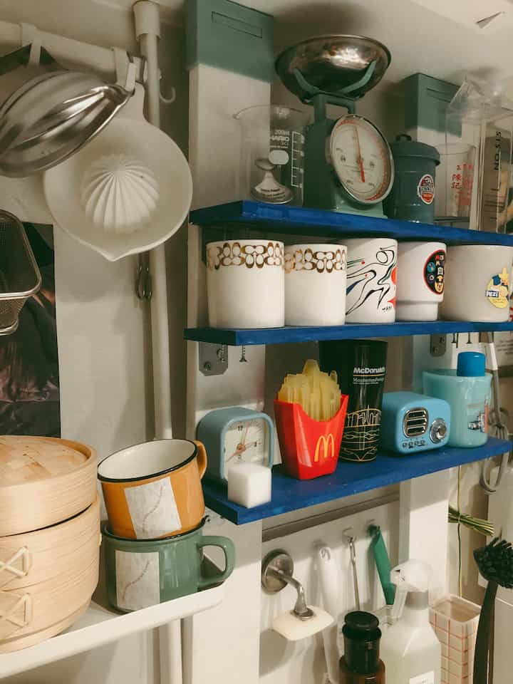 Natural tones and sky blue kitchen featuring vintage-style utensils and organized kitchenware creating a cozy atmosphere