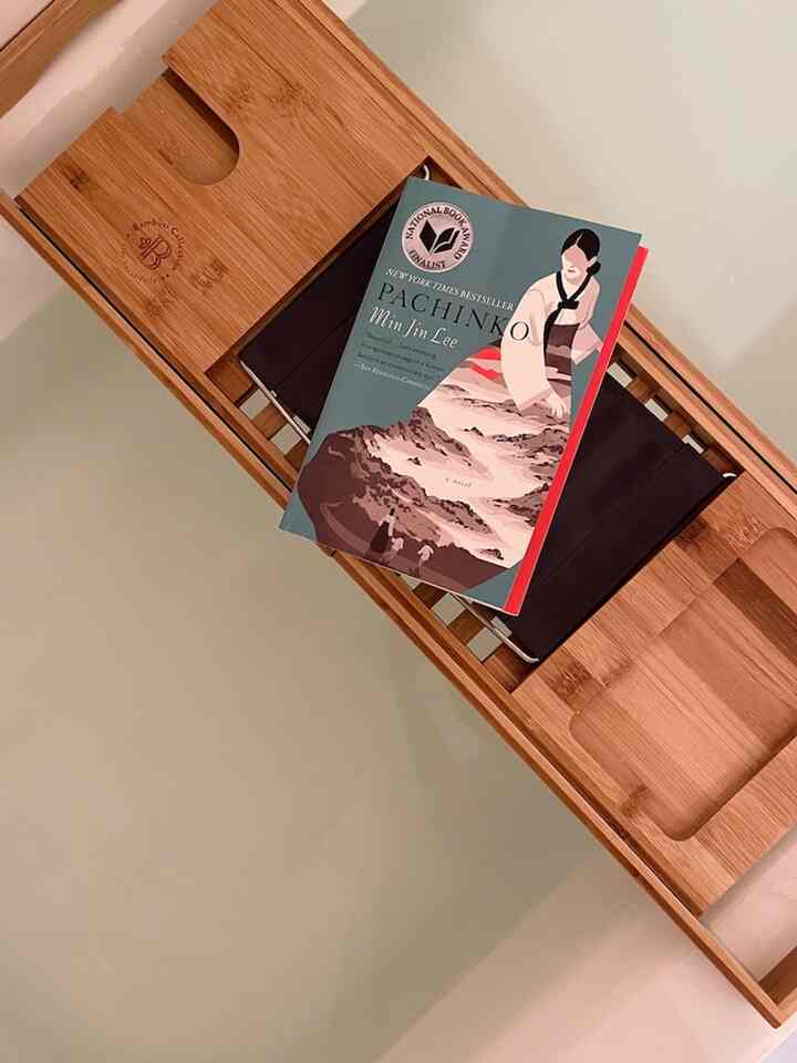 Natural-toned bathroom featuring a bamboo bathtub tray with a paperback book, creating a cozy and clean atmosphere