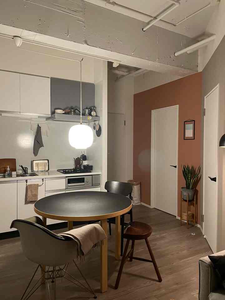 Natural tone and modern white kitchen dining room featuring a black round dining table and chairs with cozy atmosphere