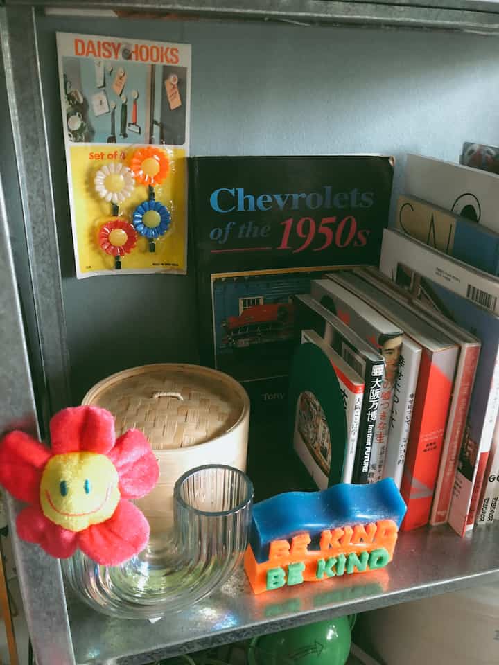 ナチュラルカラーのメタル棚に本とアジアンスタイルの竹蒸し器が配置された雰囲気のあるインテリア