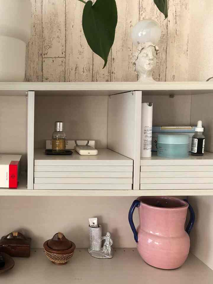 Beige and natural tone room featuring wallpaper and shelves with organized decorative items, creating a clean and natural vibe