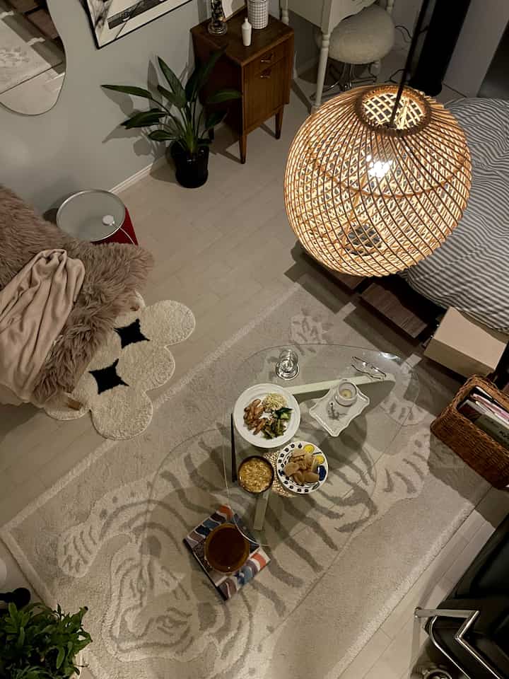 Natural-tone small living room featuring rattan lighting and plants with a cozy interior atmosphere