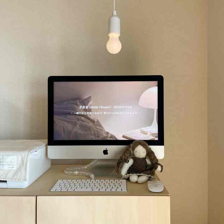 ベージュ色調のホームオフィス、iMacとペンダントライトが配置されたモダンなデスク環境